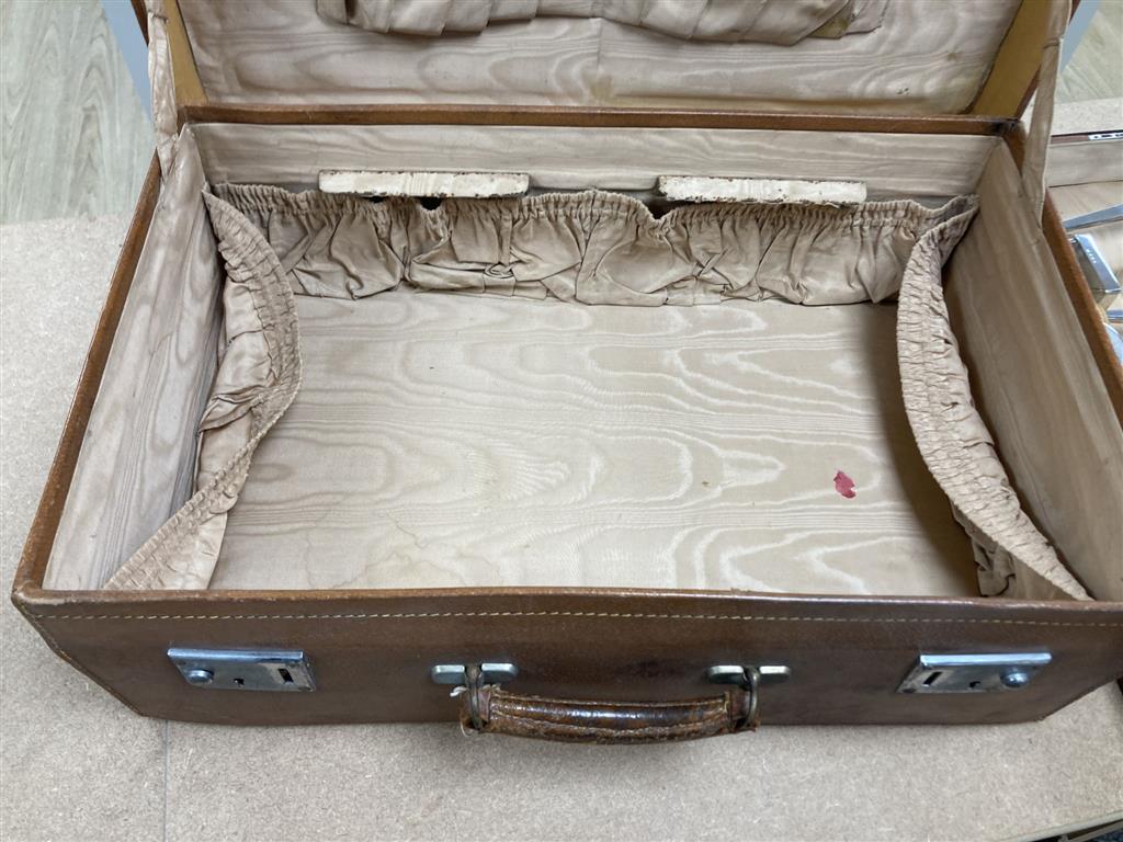 A 1930s Art Deco travelling toilet case, containing eleven silver mounted jars, mirror, and brushes.